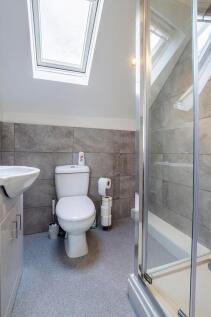 A modern bathroom featuring a bright skylight, ...