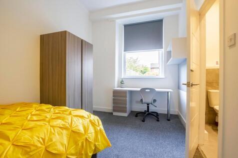 A bright and clean single bedroom featuring a c...