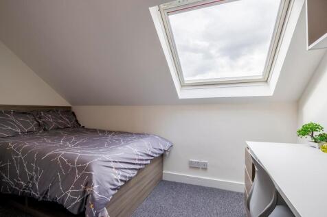 A bright and clean single bedroom featuring a c...