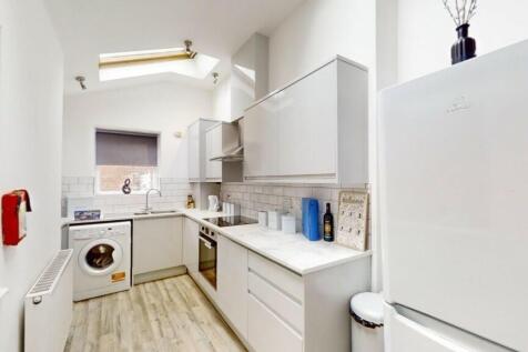 Bright and modern kitchen featuring white cabin...