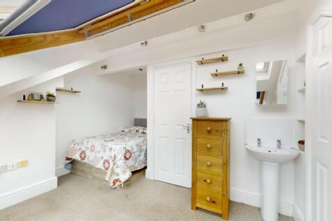 A cozy and bright attic bedroom featuring a sin...