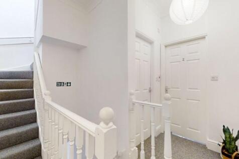 Bright and tidy hallway featuring clean white w...