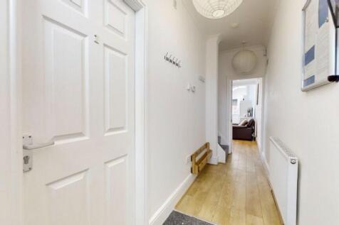 A bright and tidy hallway featuring light woode...