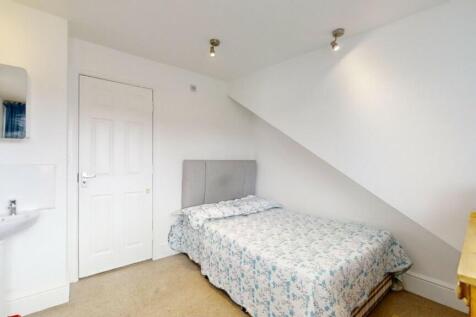 A neatly arranged single bedroom featuring a co...