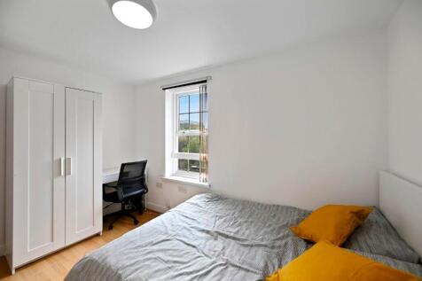 A bright and clean master bedroom featuring a c...