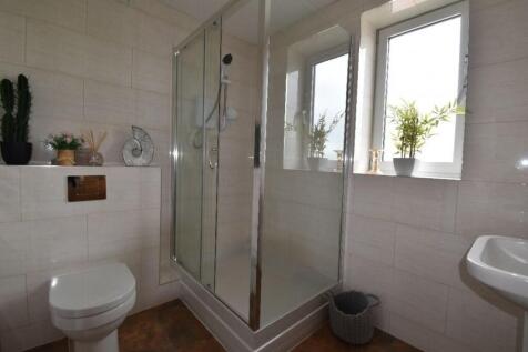 Bright and modern bathroom suite featuring a gl...