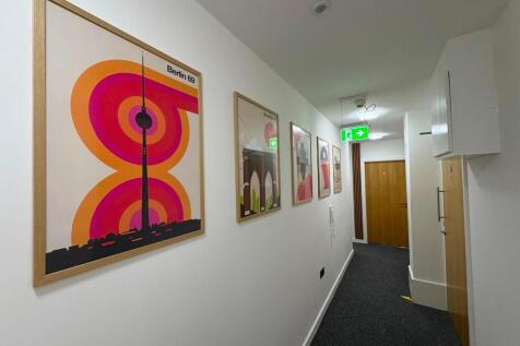 A neat and well-lit hallway featuring modern wa...