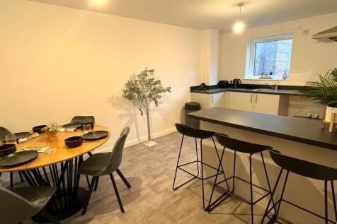 Modern kitchen with sleek black countertops and...