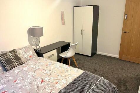 A neat and comfortable single bedroom featuring...