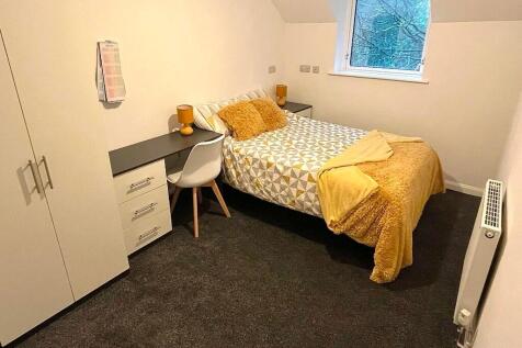 Cozy single bedroom featuring a comfortable bed...