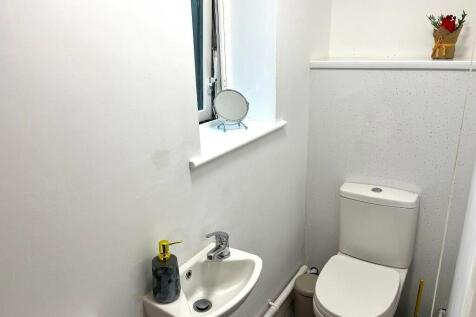 A clean and tidy small toilet room featuring a ...