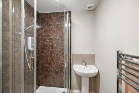 A clean and modern bathroom featuring a glass-e...