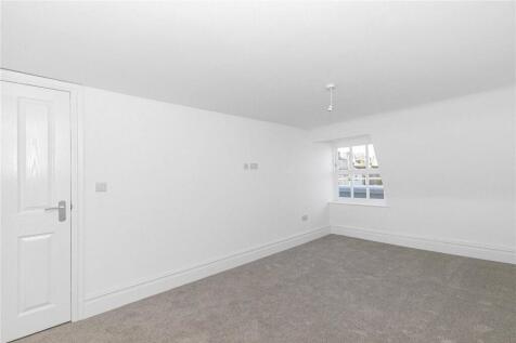 Bright and spacious master bedroom with neutral...