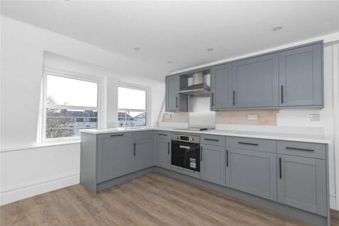 Bright, modern kitchen featuring sleek grey cab...