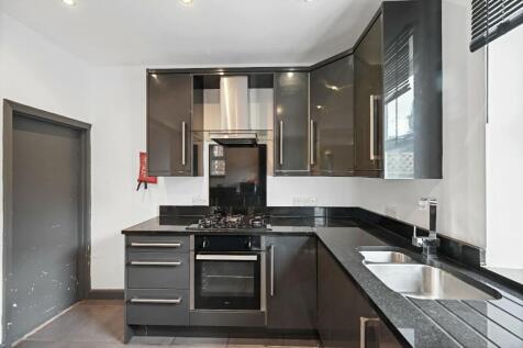 A modern kitchen featuring sleek black cabinetr...