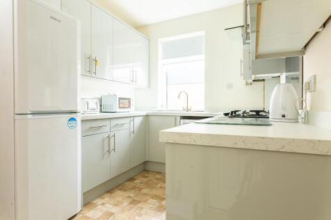 Bright and modern kitchen featuring white cabin...