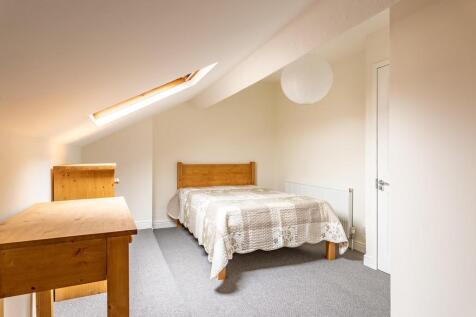 A bright and cozy bedroom with a single bed, wo...