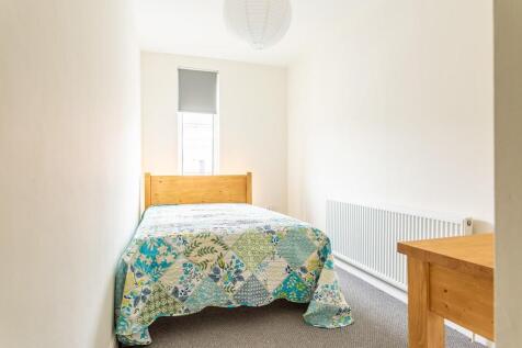A bright and tidy single bedroom featuring a co...