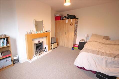 A spacious, well-kept bedroom featuring a comfo...