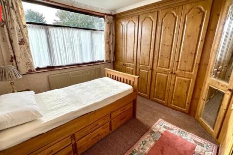 Cozy single bedroom featuring a large window al...