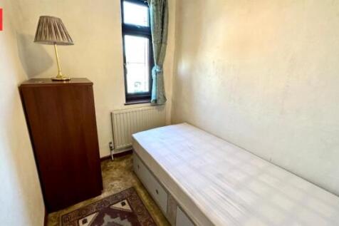 A compact, well-lit bedroom featuring a single ...