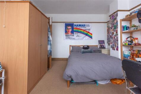 A cozy bedroom featuring a neatly made single b...