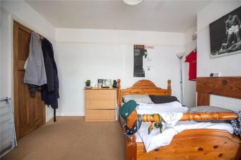 Cozy single bedroom featuring a wooden bed fram...