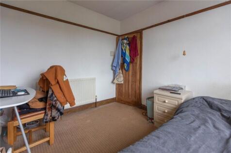 A simple and cozy single bedroom featuring a si...