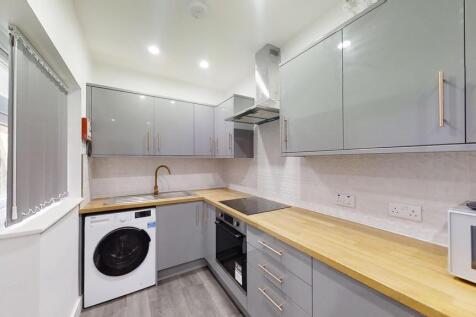 Modern kitchen with sleek grey cabinetry, woode...
