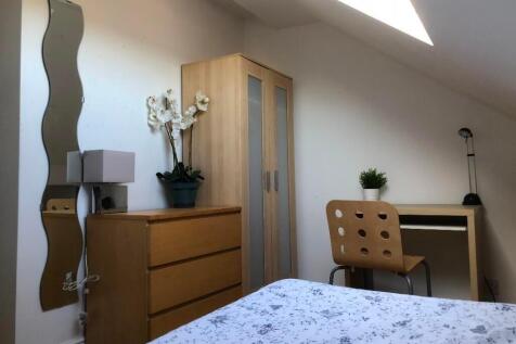 Bright and cozy bedroom featuring a comfortable...