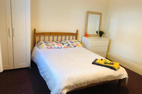 A cozy double bedroom featuring a neat wooden b...