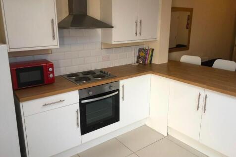 Bright and modern kitchen featuring clean white...