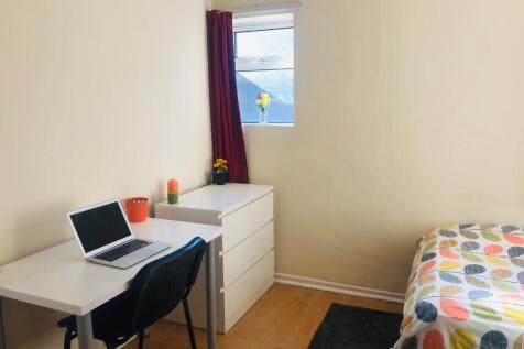 A cozy, well-kept bedroom with a desk and chair...