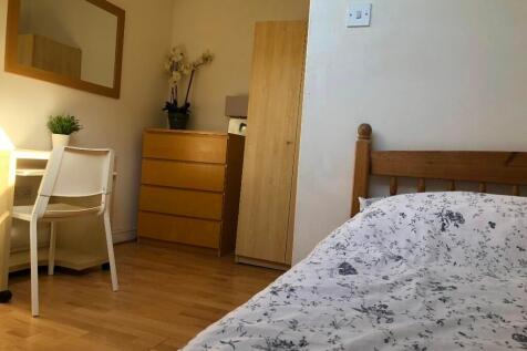 A cozy single bedroom featuring a wooden bed wi...