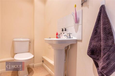 A clean and neat single toilet space with a ped...