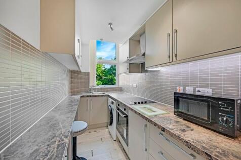 A bright and modern kitchen featuring sleek cab...
