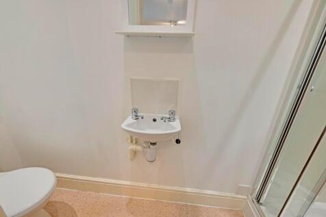 A clean and modern bathroom featuring a compact...