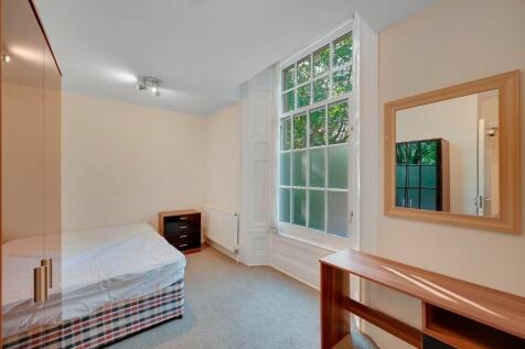 A clean and simple single toilet room with a wi...