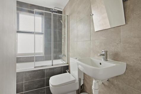 A modern bathroom suite featuring a bathtub wit...