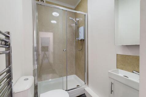 Modern bathroom suite featuring a large walk-in...