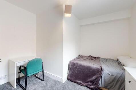 A neat and simple single bedroom featuring a co...