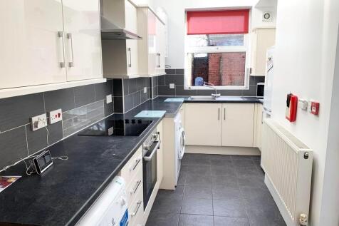 A modern, well-maintained kitchen with sleek bl...