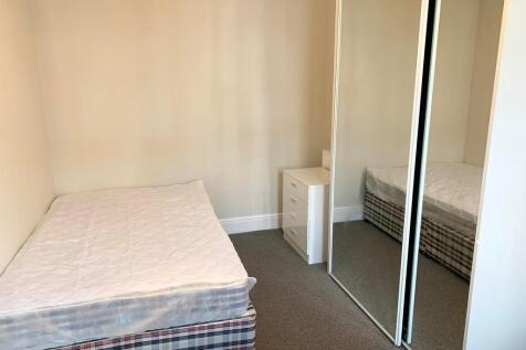 A neat and simple single bedroom featuring a co...