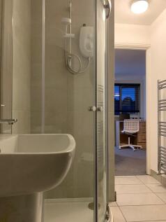 Modern bathroom featuring a clean glass-enclose...