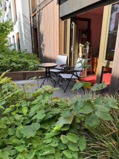 A charming garden patio area with lush greenery...