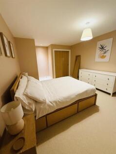 A clean and cozy double bedroom featuring a com...