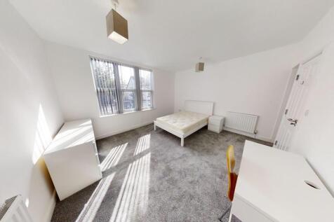 Bright double bedroom featuring large windows t...