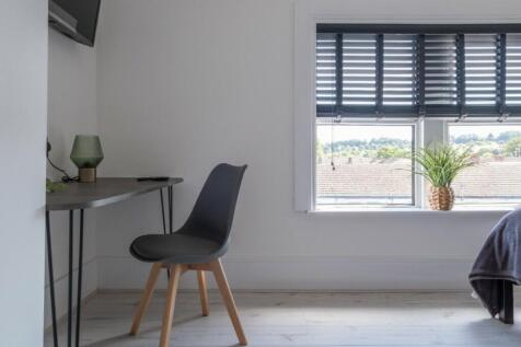 This stylish double bedroom features a modern d...