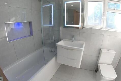 Bright and modern bathroom featuring a bathtub ...