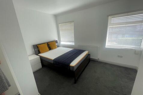 This inviting double bedroom features a comfort...